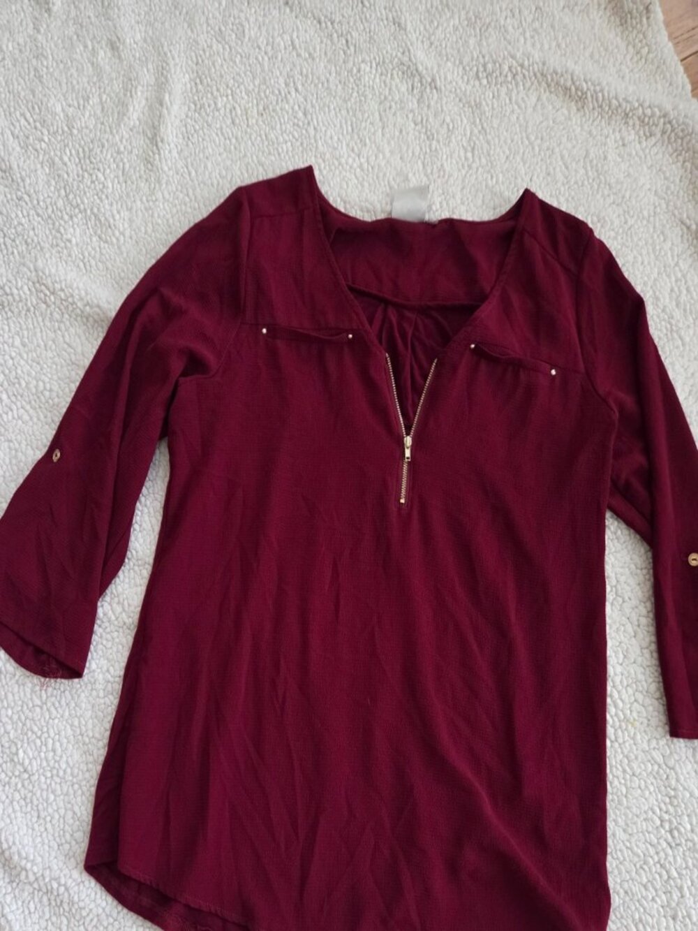 Burgundy textured long sleeve blouse with gold zipper neckline and roll-tab slee